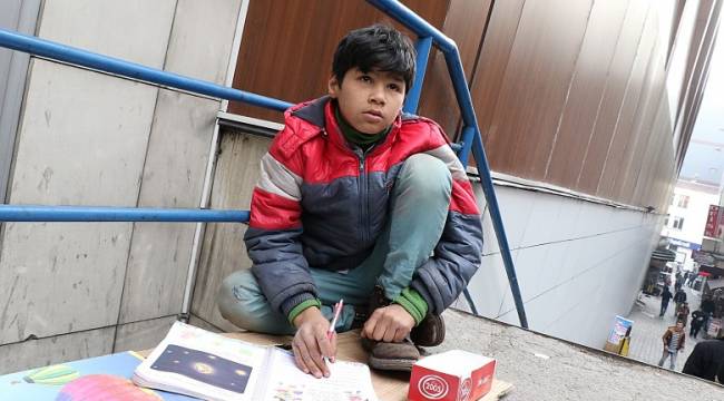 Sokakta hem ders çalışıyor hem de ailesi için mendil satıyor