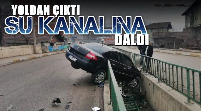 Yoldan çıkan otomobil su kanalında askıda kaldı
