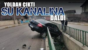 Yoldan çıkan otomobil su kanalında askıda kaldı