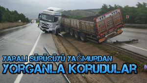 Yaralı sürücüyü yağmurdan yorganla korudular