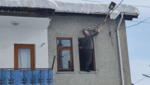 Canını hiçe sayarak çatıdaki karları temizledi