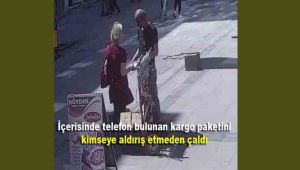 İçerisinde telefon bulunan kargo paketini kimseye aldırış etmeden çaldı