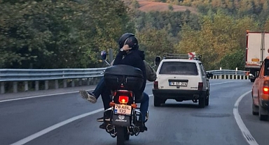 Motosiklette bacak bacak üstüne atarak yolculuk yaptı